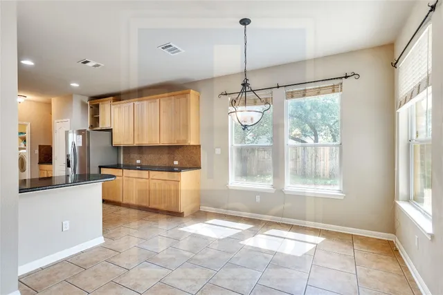 a large kitchen with kitchen island granite countertop a window and a chandelier