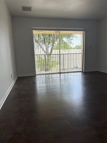 an empty room with wooden floor and entrance