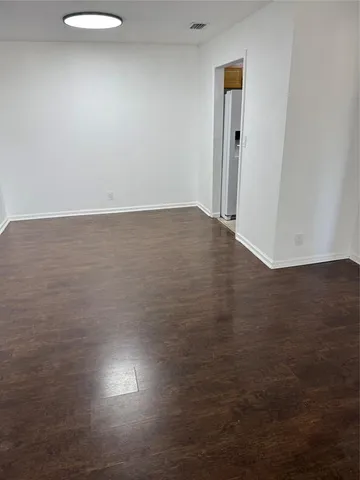an empty room with wooden floor and entrance
