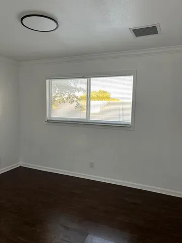 an empty room with wooden floor and closet