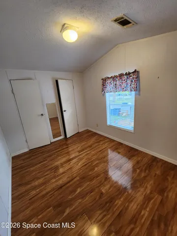 a view of empty room with wooden floor