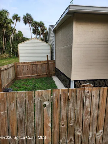 a view of a wooden house with a wooden fence