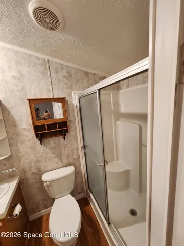 a bathroom with a toilet and a shower