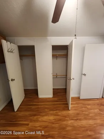 an empty room with wooden floor and entrance