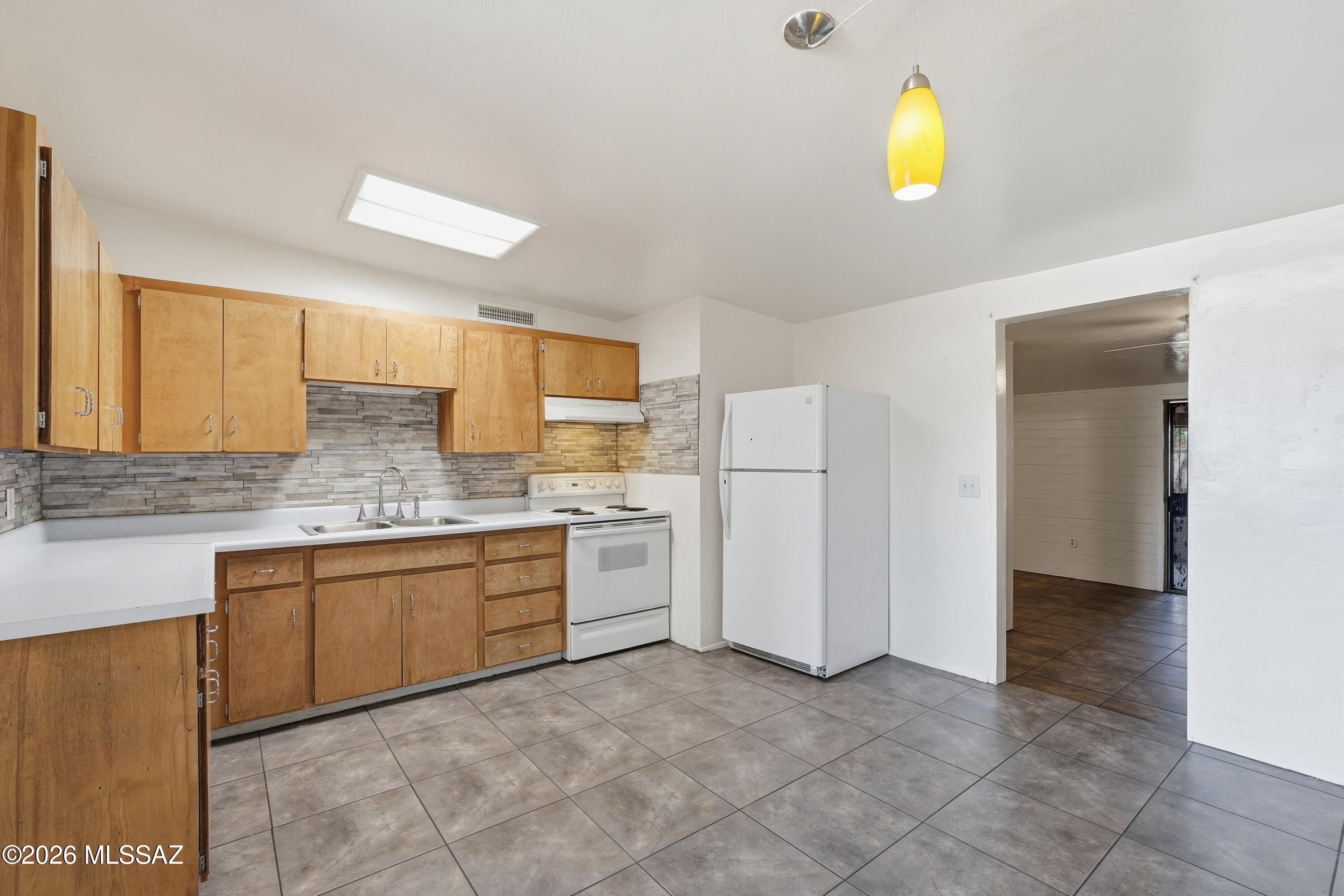 1808 West Caravelle Road Tucson, AZ 85713 - Photo 14 of 38 a kitchen with a sink and refrigerator