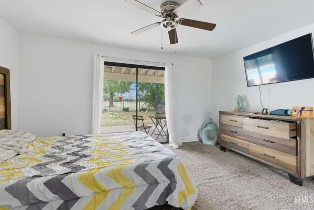 a bed room with a bed a television and a large window