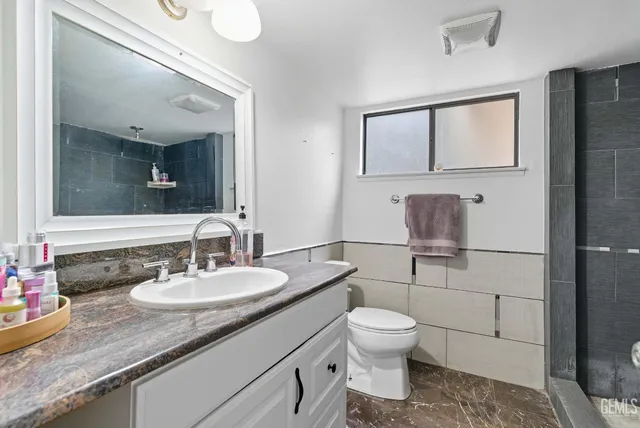 a bathroom with a toilet a sink and mirror