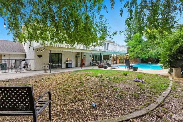 a view of a house with a yard patio and swimming pool