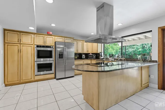 a kitchen with stainless steel appliances granite countertop a stove a sink and a refrigerator