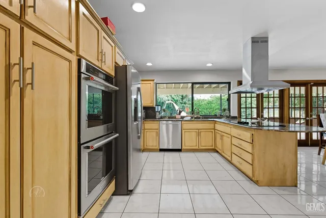 a kitchen with stainless steel appliances granite countertop a refrigerator and a stove top oven
