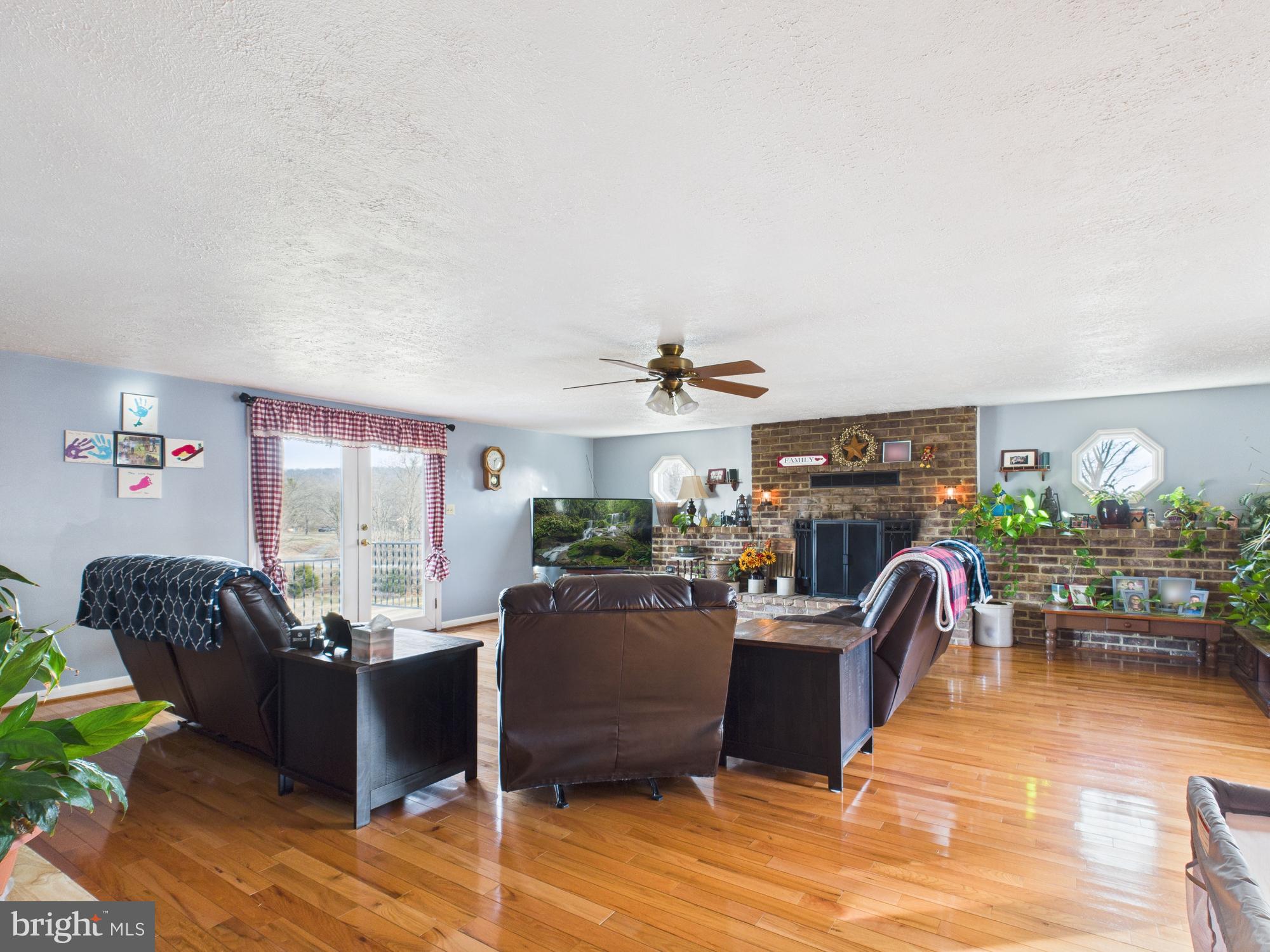 364 Bethel Grange Road Winchester, VA 22603 - Photo 25 of 52 a living room with furniture a chandelier and a fireplace