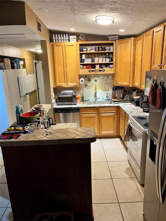 4340 Lagg Avenue Fort Myers, FL 33901 - Photo 14 of 22 a kitchen with stainless steel appliances a sink stove and cabinets