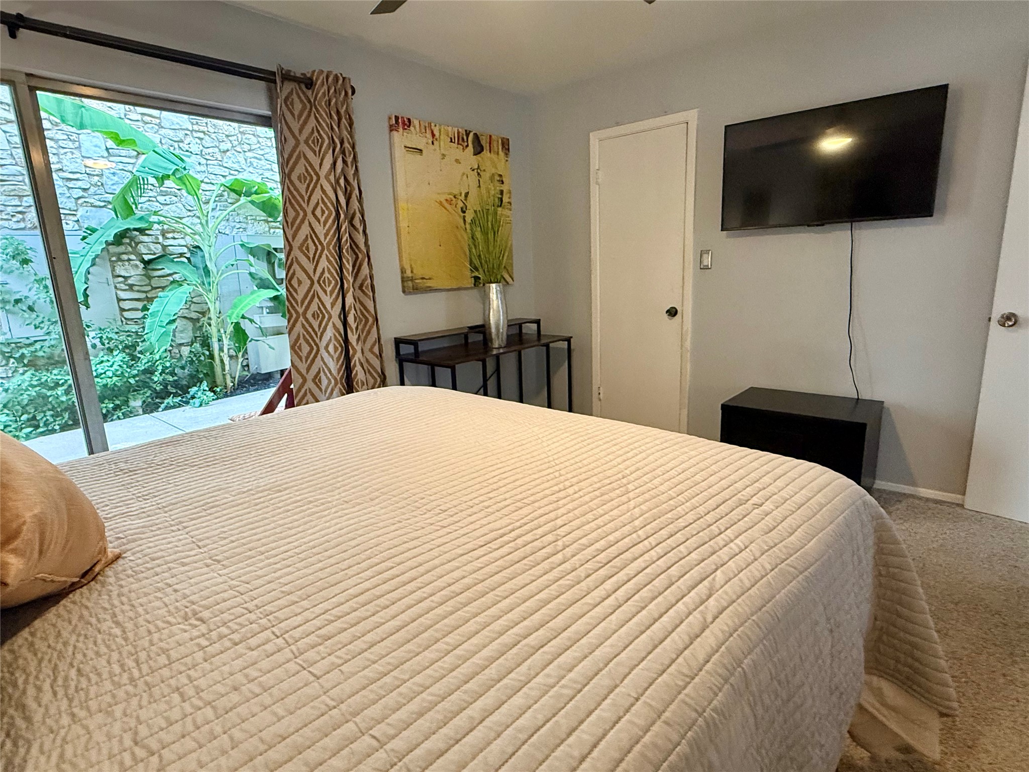 500 East Riverside Drive, Unit 149 Austin, TX 78704 - Photo 8 of 26 Sliding glass doors open from this bedroom to a private, stone-walled patio garden.