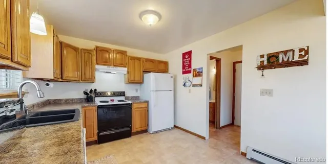 a kitchen with a refrigerator a stove top oven a sink and dishwasher
