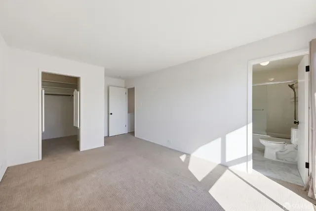 a view of an empty room and a bathroom