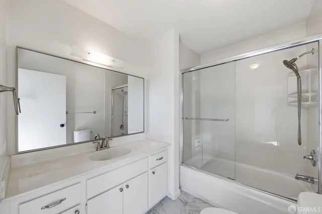 a bathroom with a tub shower sink and mirror