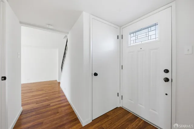 a view of a hallway with wooden floor and closet area
