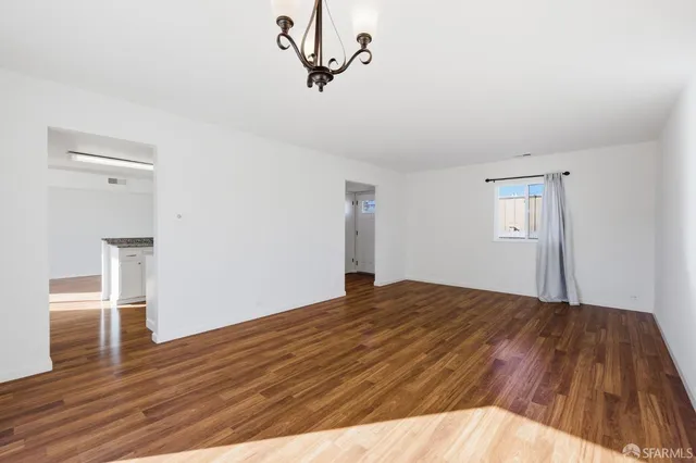 a view of empty room with wooden floor and ceiling fan