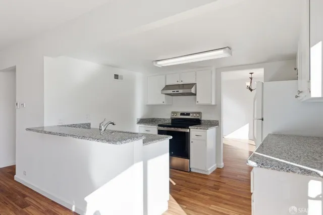 a kitchen with stainless steel appliances granite countertop a sink and a stove