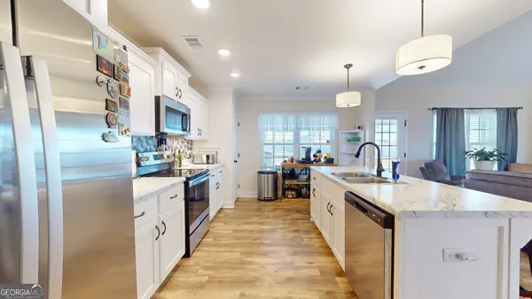 a large kitchen with stainless steel appliances lots of counter space and a sink