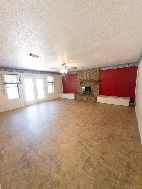 613 Laurel Road Athens, TX 75751 - Photo 4 of 13 Spacious room featuring neutral-toned tile flooring, a stone-clad fireplace with a mantel, and French doors