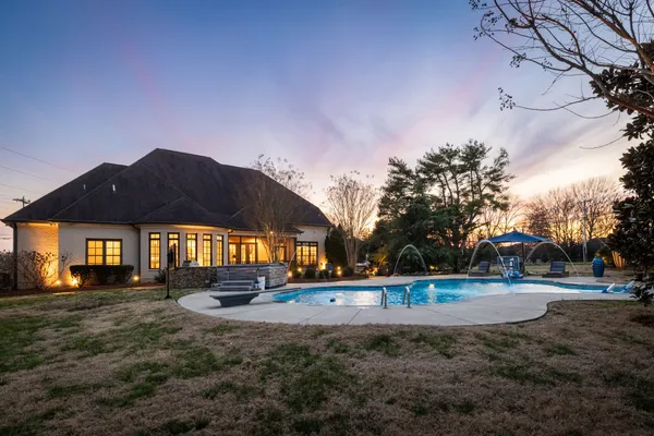 a view of a house with backyard and sitting area