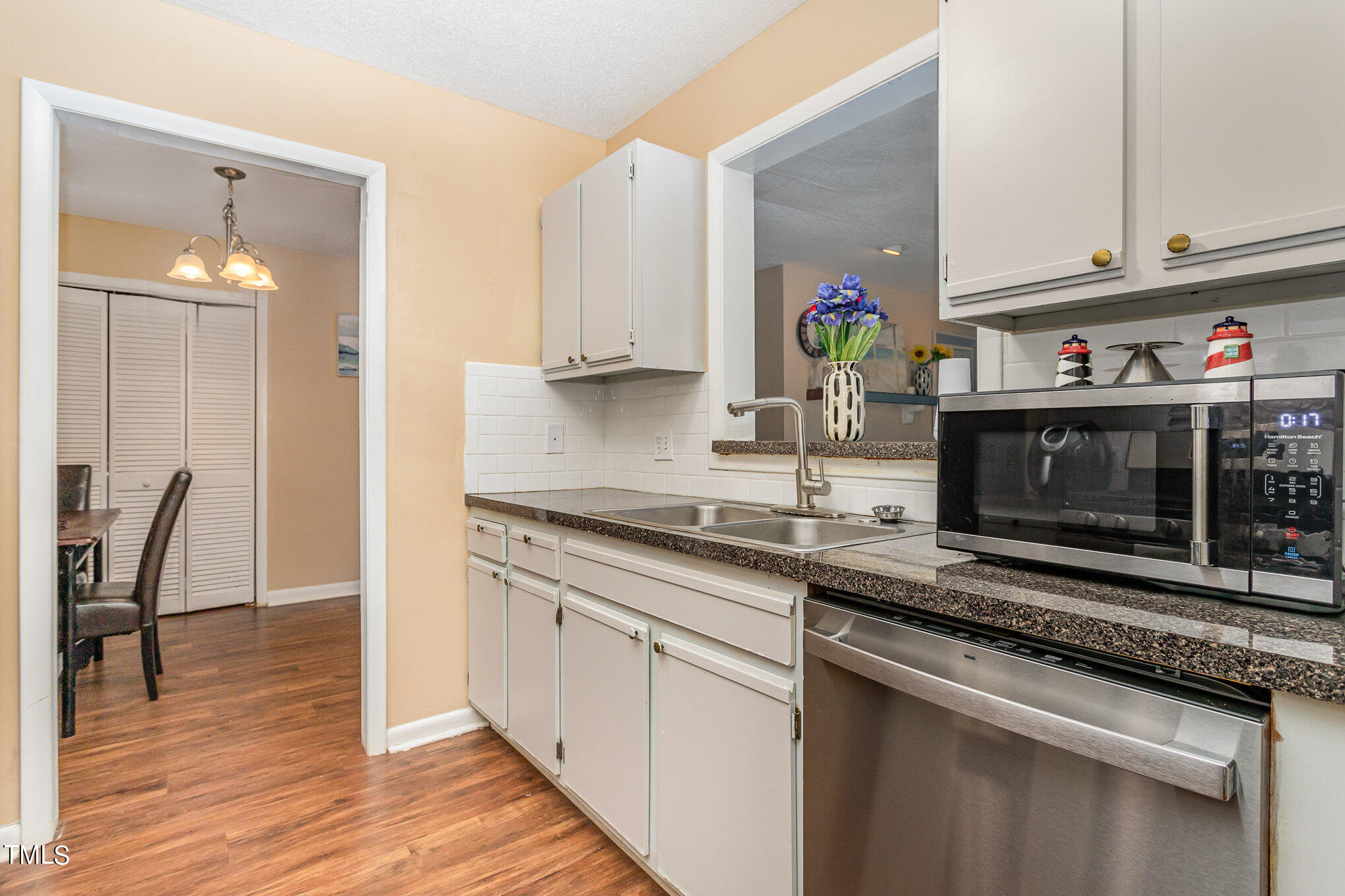 5816 Pointer Drive, Unit 102 Raleigh, NC 27609 - Photo 11 of 25 a kitchen with stainless steel appliances granite countertop a stove a sink and a microwave