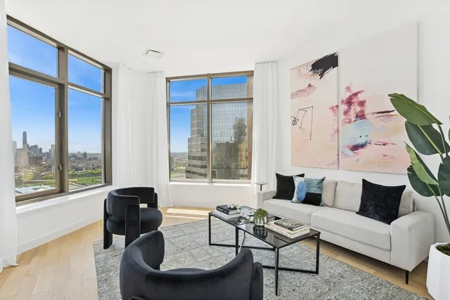 a living room with furniture and a floor to ceiling window