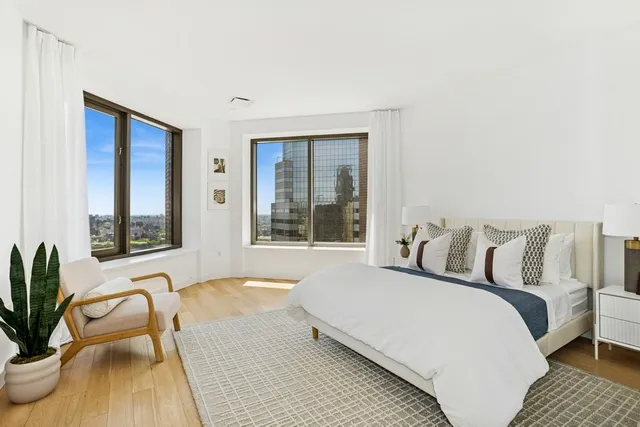 a bedroom with a bed and a large window