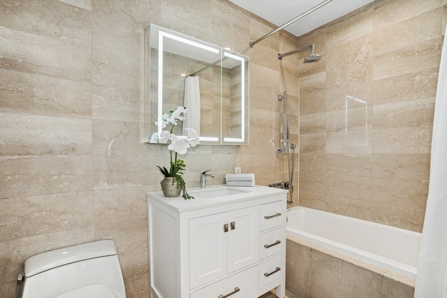 75 Wall Street, Unit PHD2 Manhattan, NY 10005 - Photo 9 of 15 a bathroom with a sink a toilet and shower