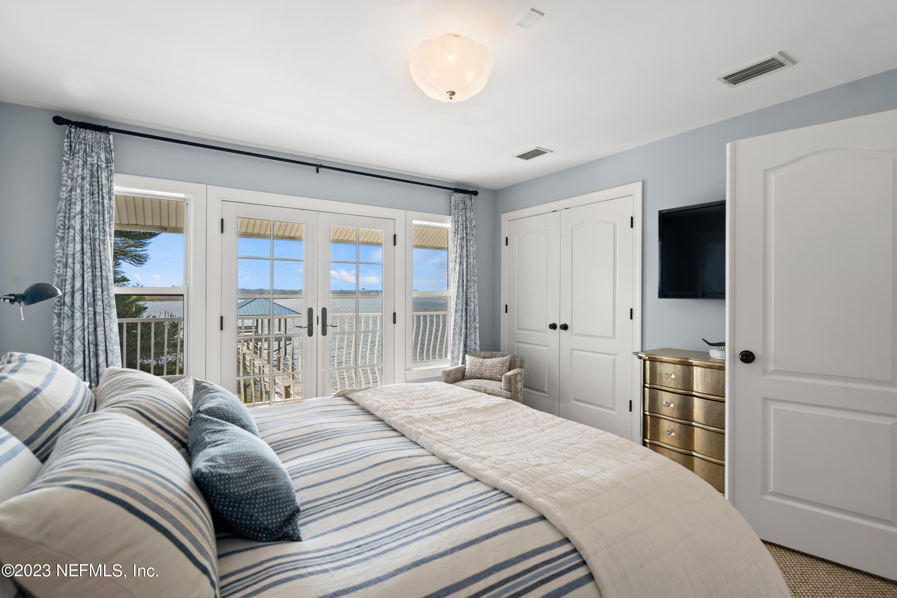 500 North Point Road St. Augustine, FL 32084 - Photo 59 of 102 a bedroom with a large bed and a flat tv screen