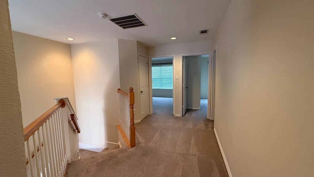 18240 Midway Road, Unit 1204 Dallas, TX 75287 - Photo 11 of 27 a view of hallway with stairs and a wooden floor