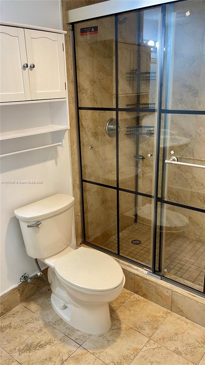 9143 Southwest 77th Avenue, Unit B505 Miami, FL 33156 - Photo 4 of 6 a white toilet sitting next to a shower