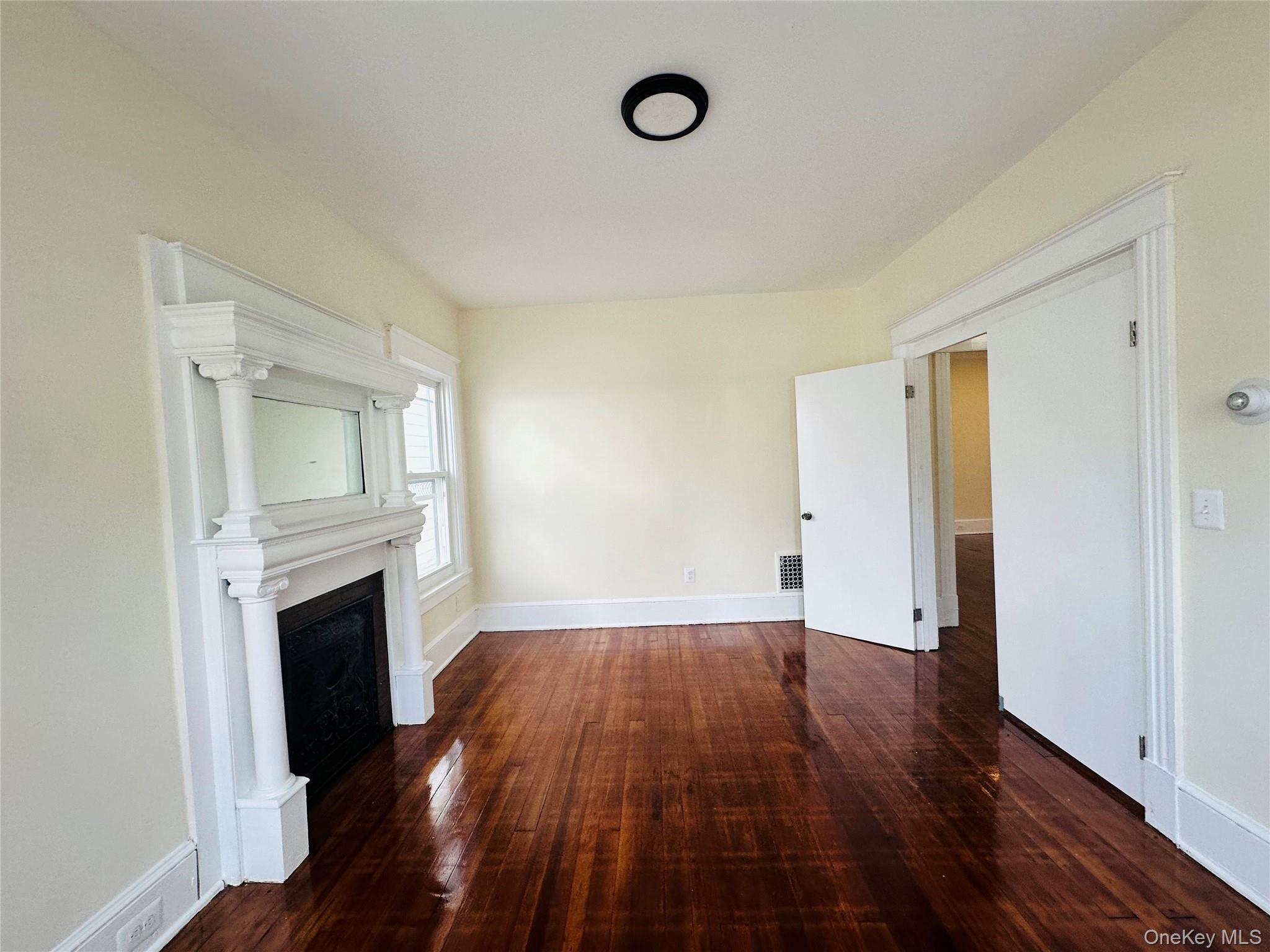 71 North Hamilton Street Poughkeepsie, NY 12601 - Photo 10 of 15 an empty room with wooden floor and fireplace