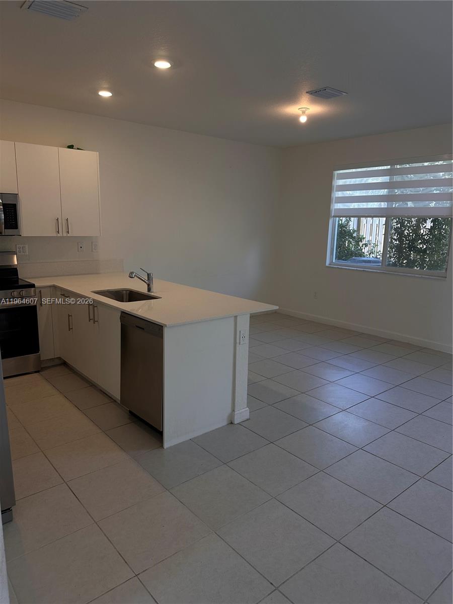 623 Southeast 13th St Circle Homestead, FL 33034 - Photo 4 of 28 a kitchen with stainless steel appliances a sink stove and cabinets