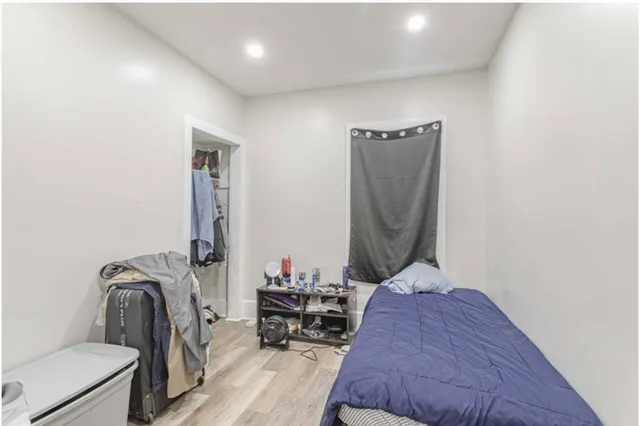 a bedroom with bed and a mirror