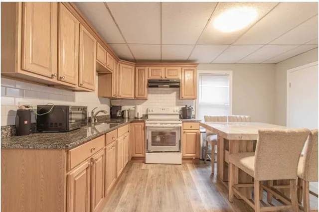 a kitchen with stainless steel appliances granite countertop a stove sink microwave and cabinets