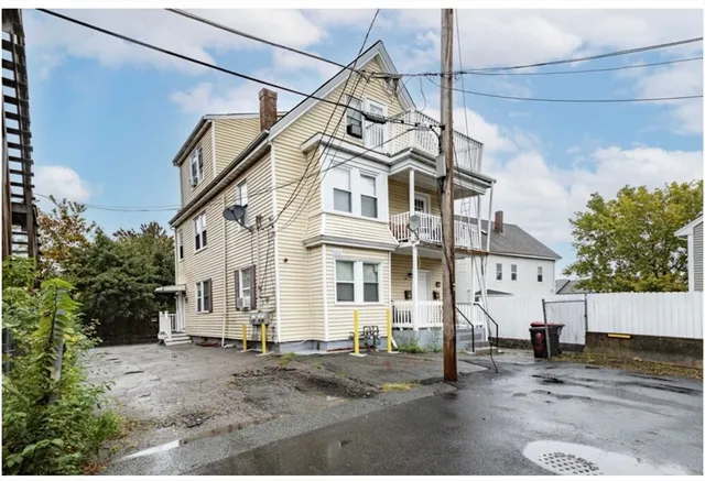 a view of a white house with a street
