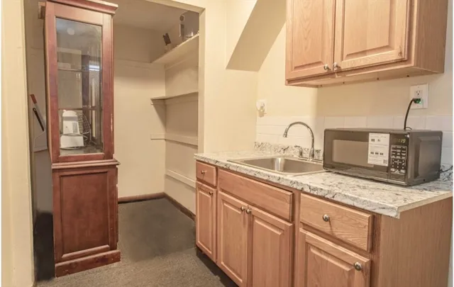 a kitchen with stainless steel appliances granite countertop a sink and a refrigerator