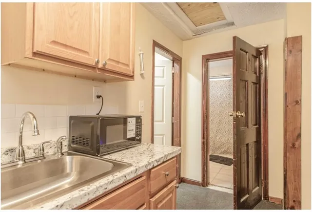 a kitchen with stainless steel appliances granite countertop a sink and a refrigerator