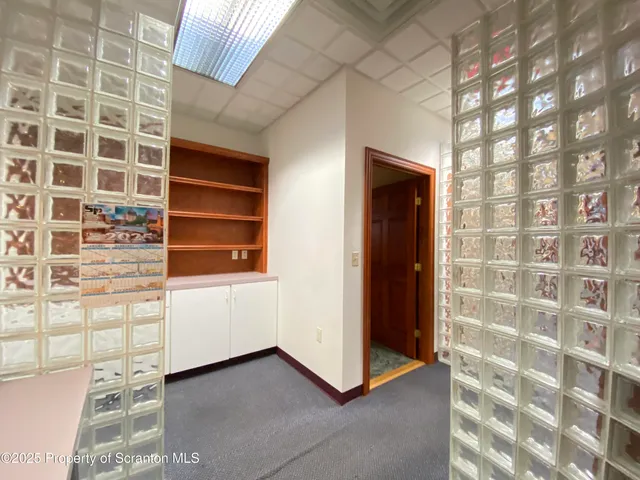 a view of an empty room with furniture and entryway