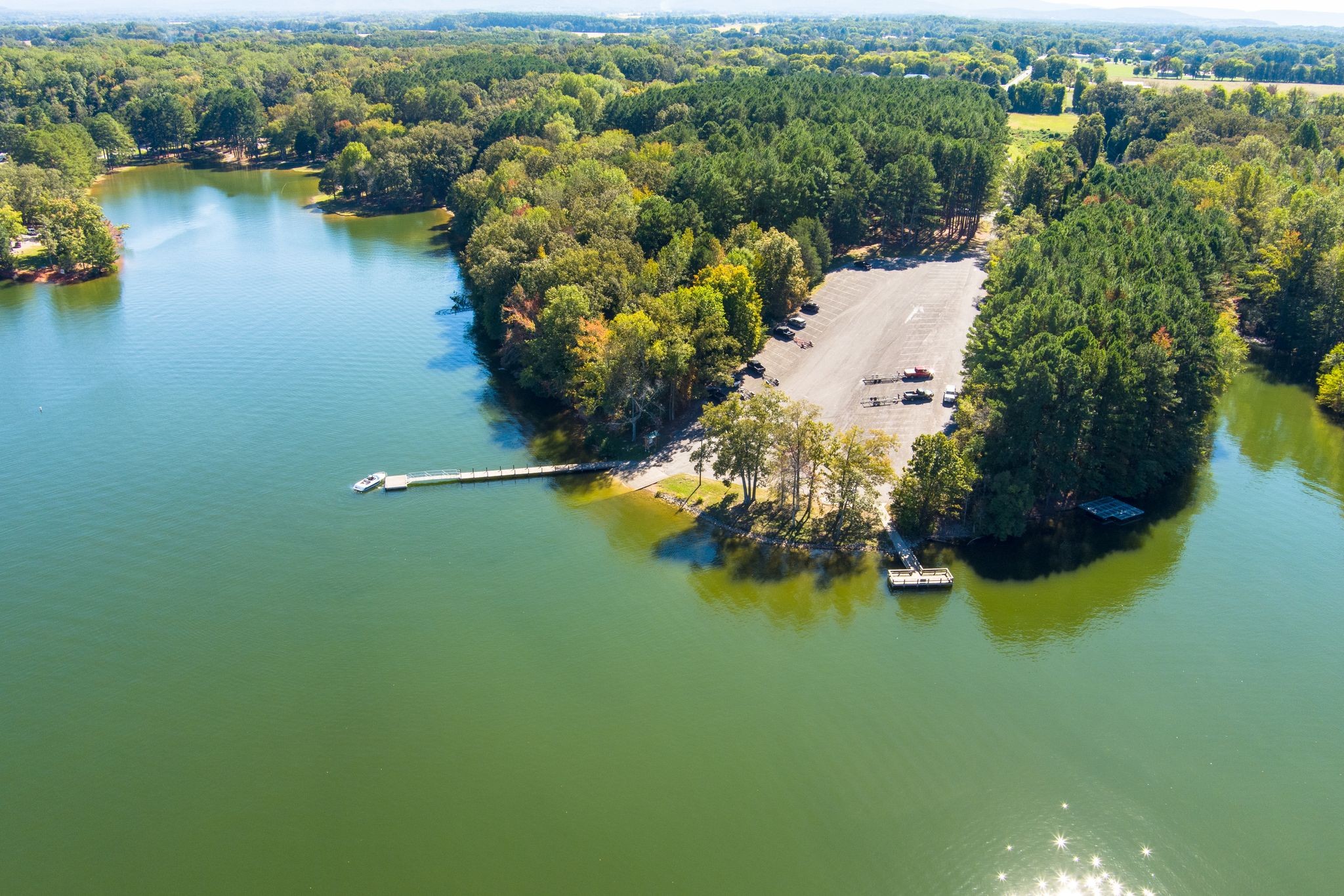 a view of a lake with boats and trees all around