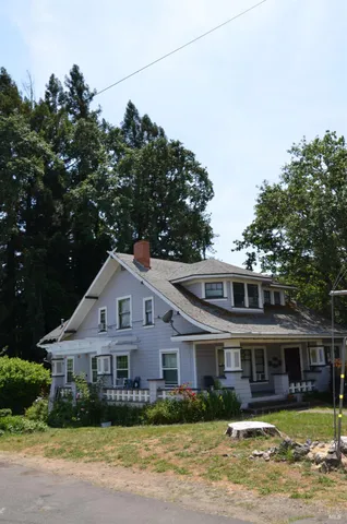 a front view of a house with a garden and plants