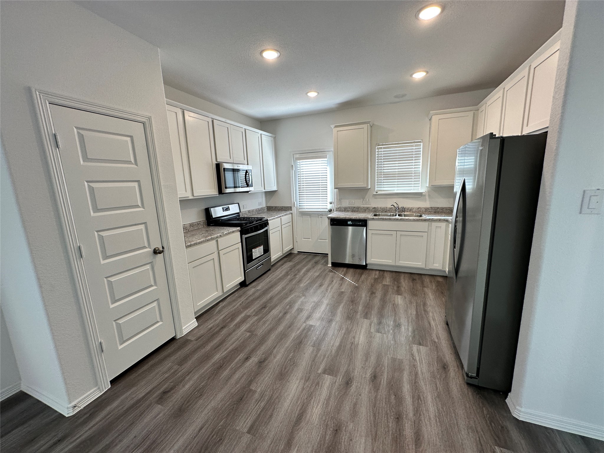 16552 Moss Lane Porter, TX 77365 - Photo 4 of 10 a kitchen with white cabinets and stainless steel appliances