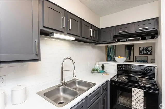 a kitchen with stainless steel appliances granite countertop a sink stove and cabinets