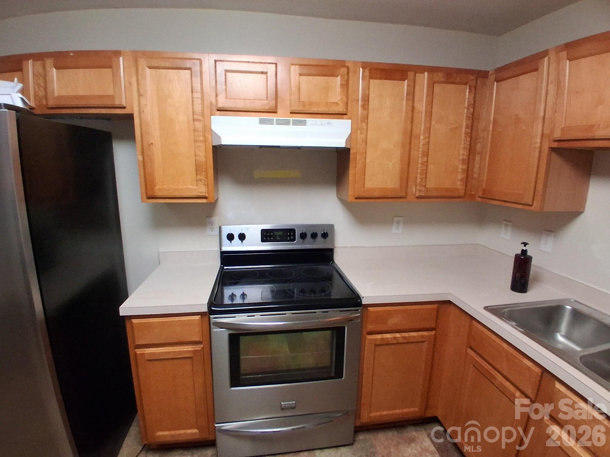 443 Tranquil Lane Willow Spring, NC 27592 - Photo 5 of 21 a kitchen with stainless steel appliances wooden cabinets and a stove top oven