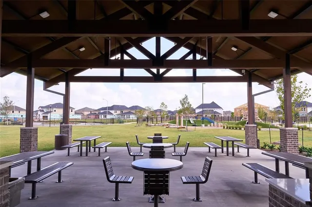 a view of a swimming pool with a table and chairs under an umbrella