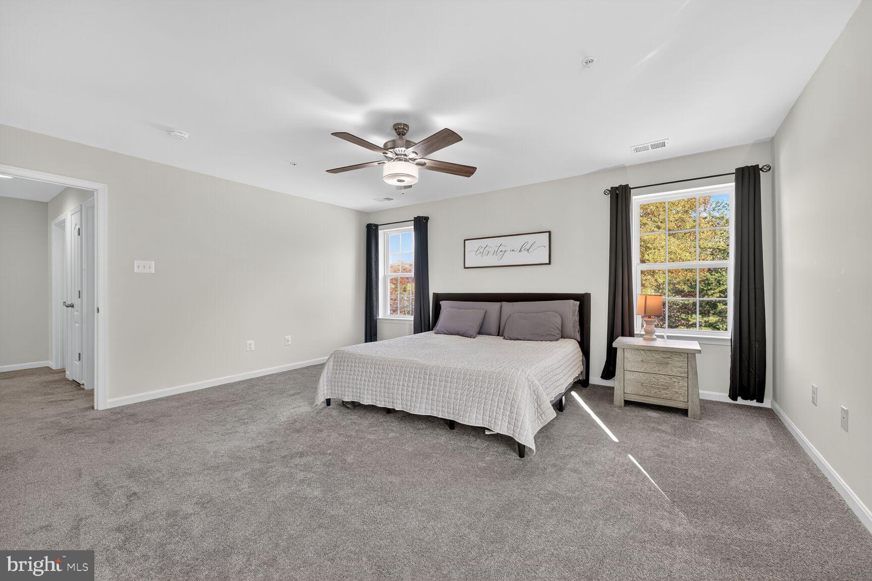 711 Yarrow Court Accokeek, MD 20607 - Photo 16 of 40 a spacious bedroom with a bed and a chandelier