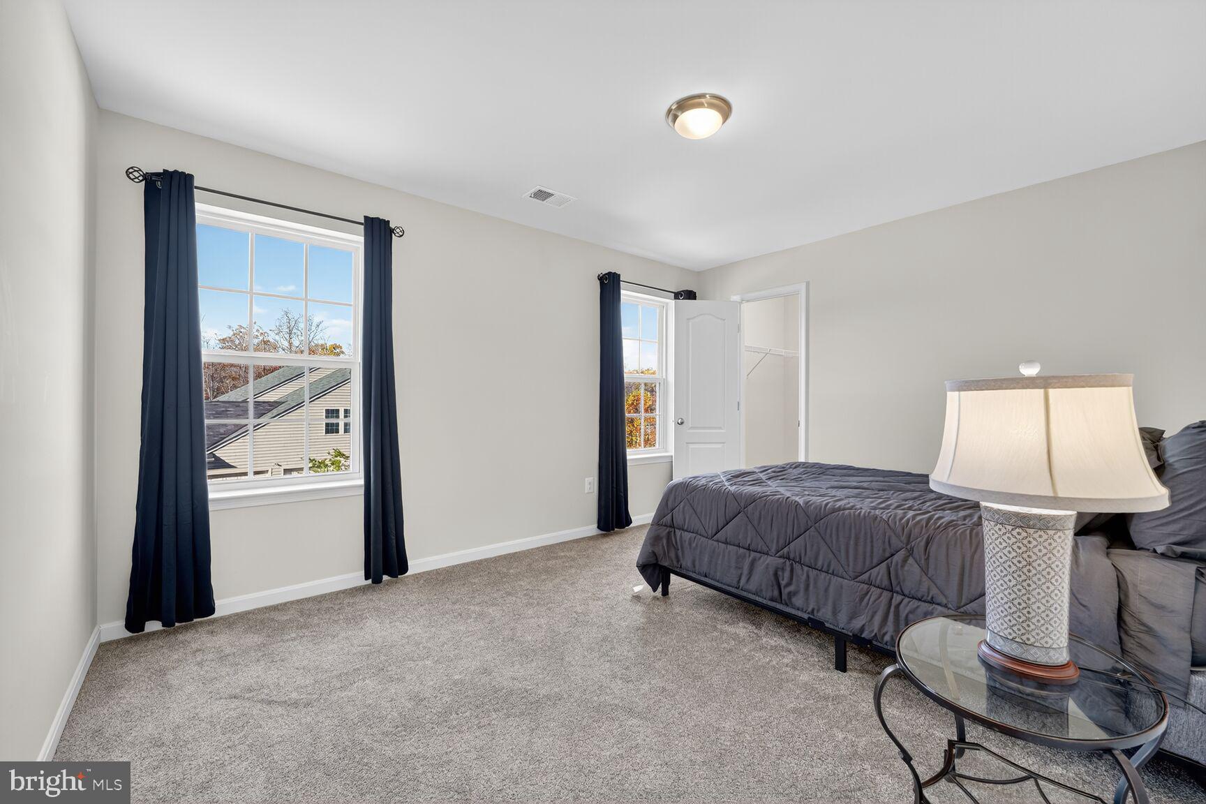 711 Yarrow Court Accokeek, MD 20607 - Photo 22 of 40 a spacious bedroom with a bed and a lamp
