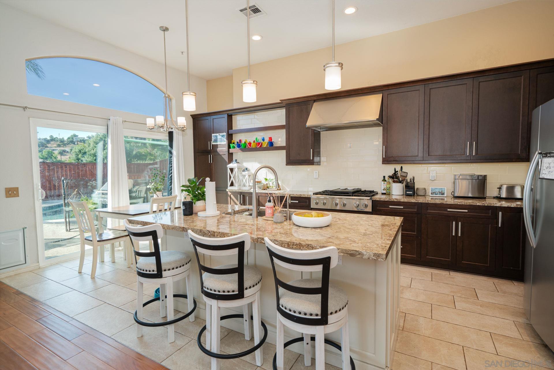 3396 Monique Lane Spring Valley, CA 91977 - Photo 16 of 31 a kitchen with a table chairs stove and microwave
